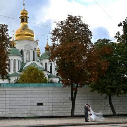 Una pareja de recién casados se besa en el centro de Kiev, justo después de su boda. | Foto:SERGEI SUPINSKY / AFP