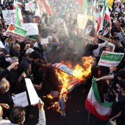 Manifestantes progubernamentales iraníes queman banderas de Estados Unidos, Israel y Gran Bretaña durante una manifestación contra las recientes protestas antigubernamentales en Irán, en Teherán. | Foto:AFP