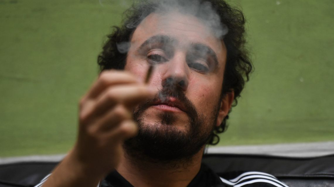 'Pulla', treasurer and technical manager of a cannabis club, smokes a joint rolled with marijuana grown in the club's grow room, in Montevideo, on August 18, 2022. 