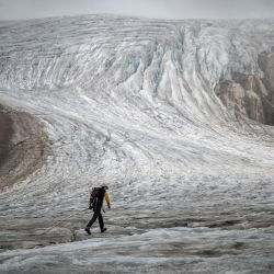 Esta foto tomada sobre Ulrichen muestra al glaciólogo y jefe de la red "Glacier Monitoring in Switzerland" (GLAMOS) Matthias Huss durante una visita con su equipo al glaciar Gries para tomar lecturas de los equipos de medición. - Los glaciares suizos batieron todos los récords de deshielo en 2022, bajo el doble efecto de un invierno seco y una larga ola de intenso calor estival. | Foto:Fabrice Coffrini / AFP