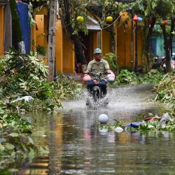 Un hombre conduce una moto en una calle inundada tras el paso del tifón Noru en la ciudad de Hoi An, provincia de Quang Nam, Vietnam. | Foto:Nhac Nguyen / AFP