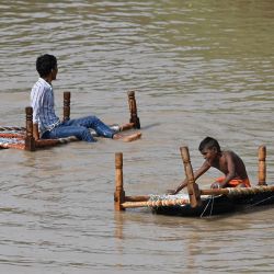 Unas personas se sientan en un charpai, un lecho tradicional, en una zona inundada después de que el nivel del agua del río Yamuna aumentara debido a las recientes lluvias, en Nueva Delhi, India. | Foto:Sajjad Hussain / AFP