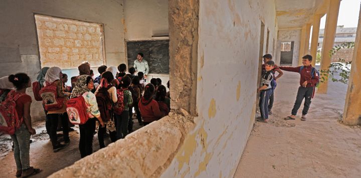 Alumnos sirios en un aula de una escuela improvisada en el lado controlado por los rebeldes de la dividida ciudad norteña de Tadif, situada a unos 32 kilómetros al este de la ciudad de Alepo.
