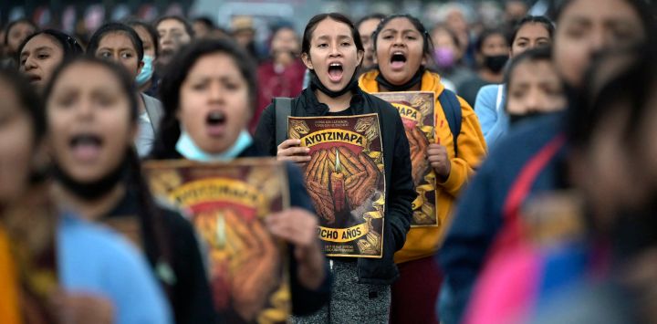 Personas gritan consignas durante una marcha en la plaza del Zócalo de Ciudad de México, para conmemorar el octavo aniversario de la desaparición de 43 estudiantes de la escuela de formación docente de Ayotzinapa.
