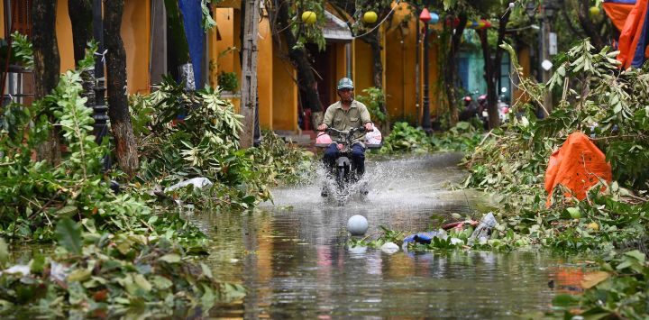 Un hombre conduce una moto en una calle inundada tras el paso del tifón Noru en la ciudad de Hoi An, provincia de Quang Nam, Vietnam.