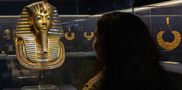 Un visitante observa la máscara funeraria de oro del antiguo faraón del Nuevo Reino Egipcio Tutankamón (1334-1325 a.C.) expuesta en el Museo Egipcio en el centro de la capital de Egipto, El Cairo, durante las celebraciones del Día Mundial del Turismo y el 200º aniversario de la egiptología por el desciframiento de los antiguos jeroglíficos egipcios.