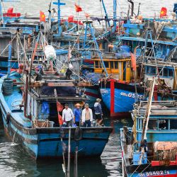 Pescadores en sus barcos atracados en el puerto para protegerse del tifón Noru en Danang. Vietnam ha tratado de evacuar a casi 400.000 personas a medida que se acerca el tifón Noru, uno de los más grandes en tocar tierra en el país, dijeron las autoridades. | Foto:NHAC NGUYEN / AFP
