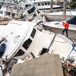 Un hombre toma fotos de los barcos dañados por el huracán Ian en Fort Myers, Florida. | Foto:Giorgio Viera / AFP