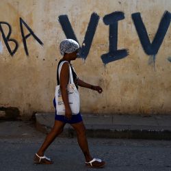Una mujer pasa junto a un grafiti que dice "Cuba viva" en una calle de La Habana. | Foto:YAMIL LAGE / AFP