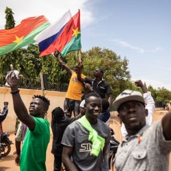 Burkina Faso y una bandera rusa se ven mientras los jóvenes se manifiestan mientras los soldados de Burkina Faso se ven desplegados en Ouagadougou. | Foto:OLYMPIA DE MAISMONT / AFP