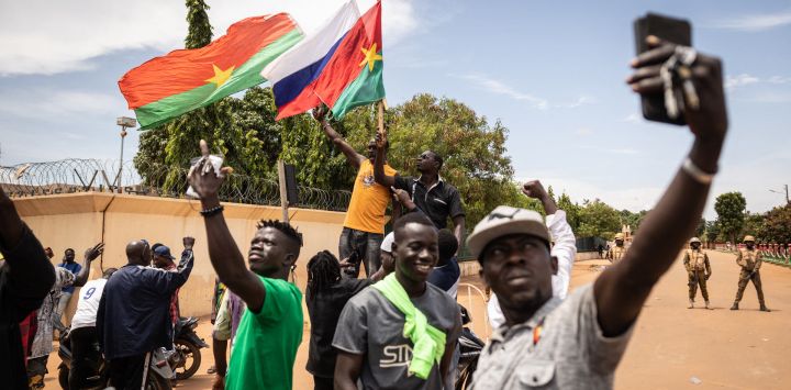 Burkina Faso y una bandera rusa se ven mientras los jóvenes se manifiestan mientras los soldados de Burkina Faso se ven desplegados en Ouagadougou.