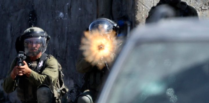 Soldados israelíes toman posición en medio de enfrentamientos con manifestantes palestinos tras una protesta contra la expropiación de tierras palestinas por parte de Israel en la aldea de Kfar Qaddum en la Cisjordania ocupada, cerca del asentamiento judío de Kedumim.