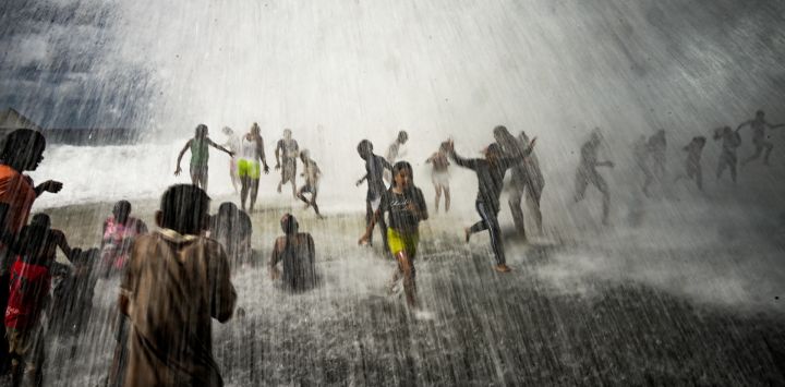 Unos niños juegan con las olas en el Malecón de La Habana, tras el paso del huracán Ian. - Las autoridades restablecen poco a poco la electricidad en Cuba tras el corte de energía en el país causado por el huracán Ian, que mató a dos personas y dejó daños generalizados.