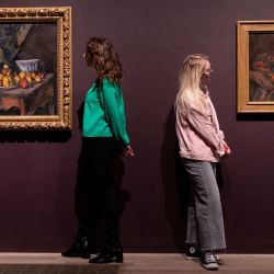 Miembros del personal posan para una fotografía con los cuadros "Naturaleza muerta con manzanas y melocotones" (izq.) y "Naturaleza muerta con jarra de jengibre, azucarero y naranjas", del artista francés Paul Cezanne, durante un avance de prensa antes de la próxima exposición "The EY Exhibition: Cezanne' en la galería Tate Modern de Londres. | Foto:NIKLAS HALLE'N / AFP