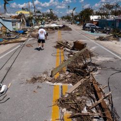 Un hombre pasa junto a los escombros esparcidos en Pine Island Road tras el paso del huracán Ian por Matlacha, Florida. | Foto:RICARDO ARDUENGO / AFP