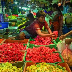 Vendedores de flores esperan a los clientes en un mercado mayorista durante el festival 'Durga Puja' en Chennai, India. | Foto:ARUN SANKAR / AFP