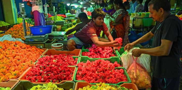 Vendedores de flores esperan a los clientes en un mercado mayorista durante el festival 'Durga Puja' en Chennai, India.