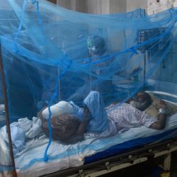 Un paciente que padece dengue descansa bajo un mosquitero en un hospital de Karachi, Pakistán. | Foto:ASIF HASSAN / AFP