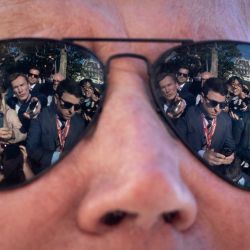 Los reporteros se ven reflejados en las gafas de sol del presidente de Estados Unidos, Joe Biden, mientras habla con la prensa antes de subir al Marine One en el Jardín Sur de la Casa Blanca en Washington, DC. | Foto:Drew Angerer/Getty Images/AFP