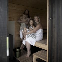 Ville Rinta, un finlandés de 37 años (arriba a la izquierda), su esposa Jenna Tuominen, de 31 años (a la derecha), su hija Seea Bottom (a la derecha), de 7 años, y su hijo Paulus, de 4 años, posan en la sauna de su casa en Isoekyroe el 11 de septiembre de 2022. - Se insta a los finlandeses a bajar los termostatos este invierno, a tomar duchas más cortas y a pasar menos tiempo en sus queridas saunas, ya que Europa se enfrenta a una crisis energética tras la guerra de Rusia en Ucrania. | Foto:Olivier Morin / AFP