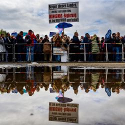 Los manifestantes se reflejan en el agua de la lluvia durante una manifestación de grupos de extrema derecha, incluido el partido Alternativa para Alemania (AfD), contra el aumento de los precios en Berlín, Alemania. | Foto:JOHN MACDOUGALL / AFP