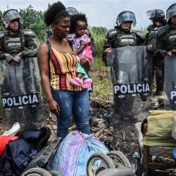 Una mujer y su bebé miran sus pertenencias mientras la policía antidisturbios los desaloja de una propiedad ocupada en Cali, Colombia. - La operación policial afecta a unas 1.500 familias que habían ocupado un inmueble en el sector de Navarra de Cali. | Foto:JOAQUIN SARMIENTO / AFP
