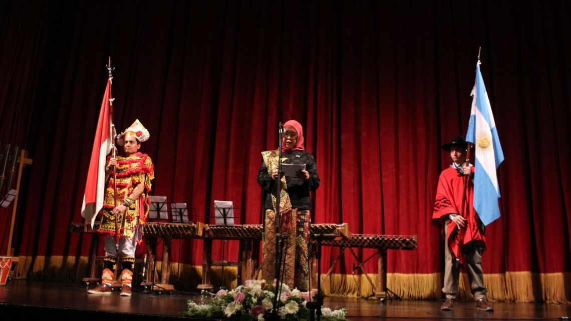 Ambassador Niniek Kun Naryatie is joined on stage by Indonesian and Argentine flag-bearers at a diplomatic event in Buenos Aires. 