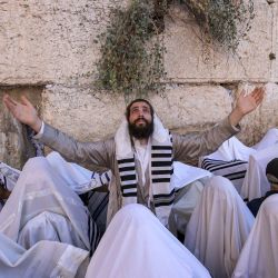 Hombres judíos, vestidos con los tradicionales mantos de oración judíos conocidos como Tallit, realizan la oración anual de los Cohanim (bendición de los sacerdotes) durante la festividad de Sucot, o la Fiesta de los Tabernáculos, en el Muro Occidental en la ciudad vieja de Jerusalén. | Foto:Menahem Kahana / AFP
