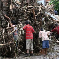 Residentes buscan a sus familiares desaparecidos entre los escombros de una casa destruida por un deslizamiento de tierra durante las fuertes lluvias en Las Tejerias, estado de Aragua, Venezuela. | Foto:YURI CORTEZ / AFP