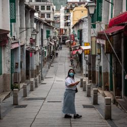 Una peatona mira mientras camina por una calle del centro histórico en Macao, China. | Foto:Eduardo Leal / AFP