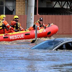 Los trabajadores de emergencia miran un coche sumergido en una calle inundada en el suburbio de Melbourne de Maribyrnong, Australia. | Foto:William West / AFP