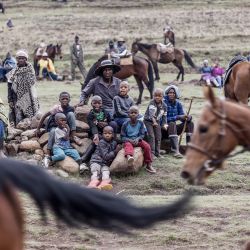 Los espectadores observan, mientras los jinetes de Lesotho montados en ponis basutos compiten en una carrera de caballos tradicional en Semonkong, un pueblo remoto en las montañas de Maluti. | Foto:MARCO LONGARI / AFP