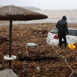 Un hombre observa un vehículo en la playa de la popular localidad de Agia Pelagia, en la isla de Creta, al sur de Grecia, tras las inundaciones repentinas. | Foto:COSTAS METAXAKIS / AFP