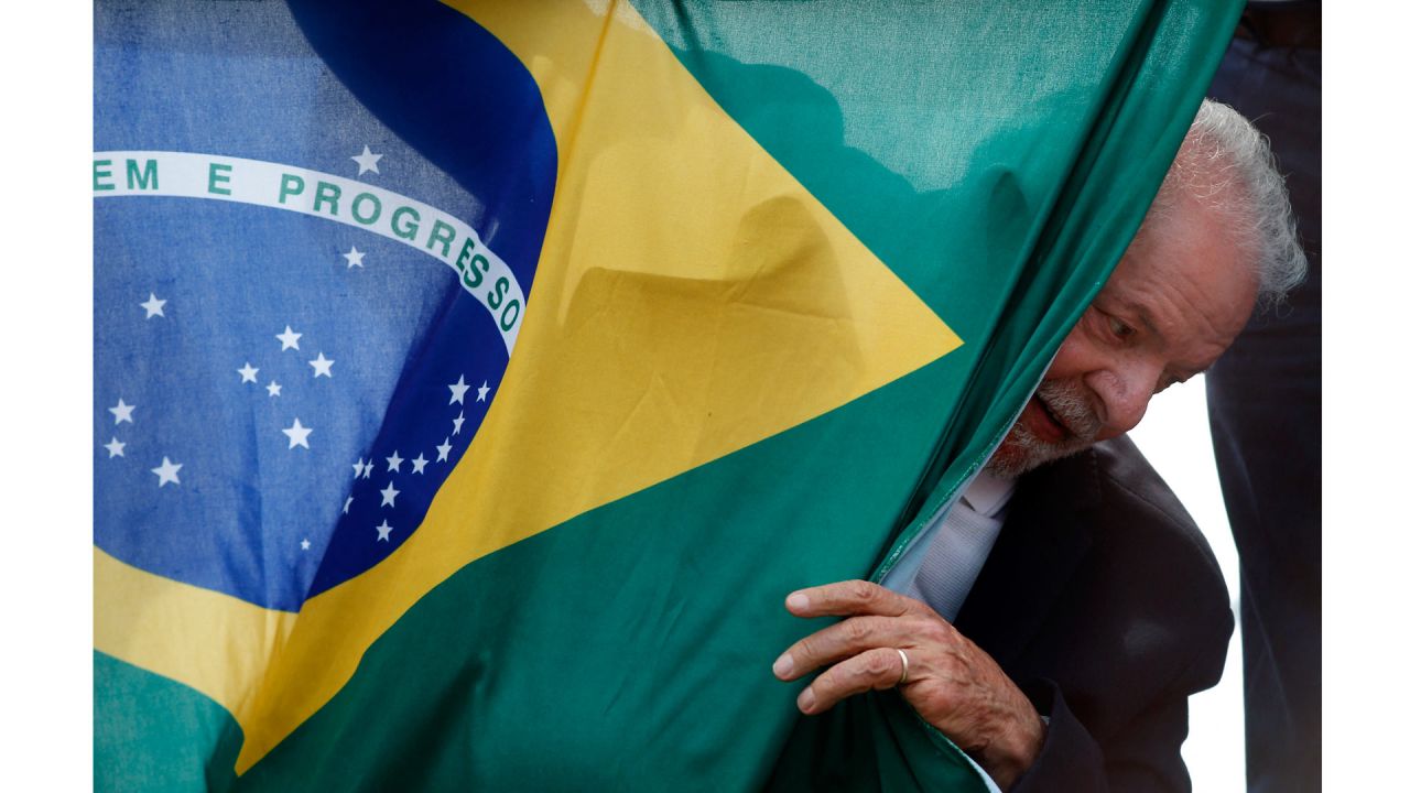 El ex presidente brasileño (2003-2010) y candidato presidencial por el izquierdista Partido de los Trabajadores (PT), Luiz Inacio Lula da Silva, aparece detrás de una bandera nacional brasileña durante un acto de campaña en Sao Mateus, estado de Sao Paulo, Brasil. | Foto:MIGUEL SCHINCARIOL / AFP