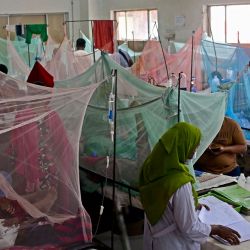 Unas personas consuelan a sus hijos enfermos de dengue en un hospital gubernamental de Dhaka, Bangladesh. | Foto:MUNIR UZ ZAMAN / AFP