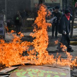 Manifestantes bloquean una calle con una barricada incendiada durante una protesta para conmemorar el tercer aniversario de un levantamiento social contra el aumento de los precios de los servicios públicos, en los alrededores de la plaza Baquedano en Santiago, Chile. | Foto:Martín Bernetti / AFP