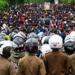 Policías hacen guardia mientras los manifestantes participan en una manifestación antigubernamental de los estudiantes universitarios que exigen la liberación de sus líderes, en Colombo, Sri Lanka. | Foto:ISHARA S. KODIKARA / AFP