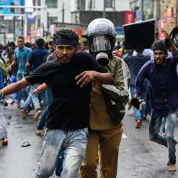 Un policía detiene a un manifestante durante una manifestación antigubernamental de los estudiantes universitarios que exigen la liberación de sus líderes, en Colombo, Sri Lanka. | Foto:ISHARA S. KODIKARA / AFP