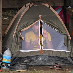 Una migrante venezolana descansa en su tienda de campaña en la aldea de Canaán Membrillo, el primer control fronterizo de la provincia de Darién en Panamá. | Foto:LUIS ACOSTA / AFP