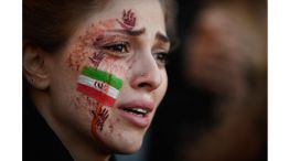 Una manifestante con una bandera iraní y las manos rojas pintadas en la cara asiste a una concentración de apoyo a las protestas iraníes, tras la muerte de la iraní Mahsa Amini en Irán.
