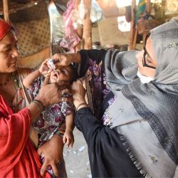 Un trabajador sanitario administra gotas de vacuna contra la polio a un niño durante una campaña de vacunación en Karachi, Pakistán. | Foto:RIZWAN TABASSUM / AFP