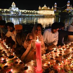 Los devotos encienden velas y lámparas de tierra mientras presentan sus respetos en el iluminado Templo Dorado con motivo del Bandi Chhor Divas, un festival sij que coincide con el Diwali, el festival hindú de las luces, en Amritsar, India. | Foto:Narinder Nanu / AFP
