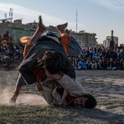 Luchadores afganos compiten en un combate de lucha tradicional en el barro en un campo en el terreno de Chaman-e- Huzuri en Kabul. | Foto:WAKIL KOHSAR / AFP