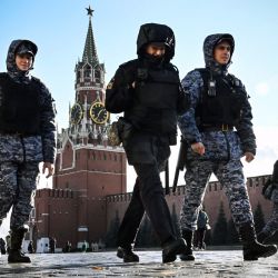 Policías y militares de la Guardia Nacional Rusa patrullan la Plaza Roja frente a la torre Spasskaya del Kremlin en Moscú, como parte de las medidas de refuerzo de seguridad. | Foto:ALEXANDER NEMENOV / AFP