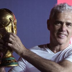 El campeón del mundo de Argentina en 1978, Alberto Tarantini, sostiene el trofeo de la Copa Mundial de la FIFA en Ezeiza, Buenos Aires, durante la gira mundial previa a la Copa Mundial de la FIFA Qatar 2022, que se celebrará entre el 20 de noviembre y el 18 de diciembre. | Foto:JUAN MABROMATA / AFP