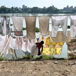 Un lavandero cuelga la ropa para secarla en la orilla del río Buriganga en Dhaka, Bangladesh. | Foto:MUNIR UZ ZAMAN / AFP