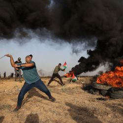 Un manifestante palestino utiliza un tirachinas para lanzar piedras a través de la frontera con Israel, al este de la ciudad de Gaza, durante los enfrentamientos con las fuerzas israelíes tras una manifestación en la frontera. | Foto:MAHMUD HAMS / AFP
