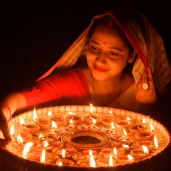 Una mujer enciende lámparas de tierra con motivo de Diwali, el festival hindú de las luces, en su casa en Guwahati, India. | Foto:BIJU BORO / AFP