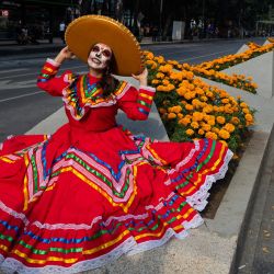 Una mujer disfrazada del personaje de La Catrina posa antes de participar en el Desfile de Catrinas, que conmemora el Día de Muertos, en Ciudad de México. | Foto:CLAUDIO CRUZ / AFP