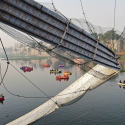 Personal de rescate realiza operaciones de búsqueda tras el derrumbe de un puente sobre el río Machchhu en Morbi, en el estado indio de Gujarat. - Al menos 130 personas murieron en la India después de que un puente peatonal de la época colonial se derrumbara, haciendo que decenas de personas cayeran al río, dijo la policía. | Foto:SAM PANTHAKY / AFP